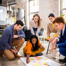 group of business people gather around a plan