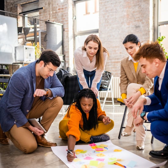 group of business people gather around a plan