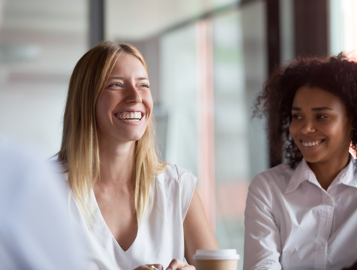 Two employees smiling with one another.