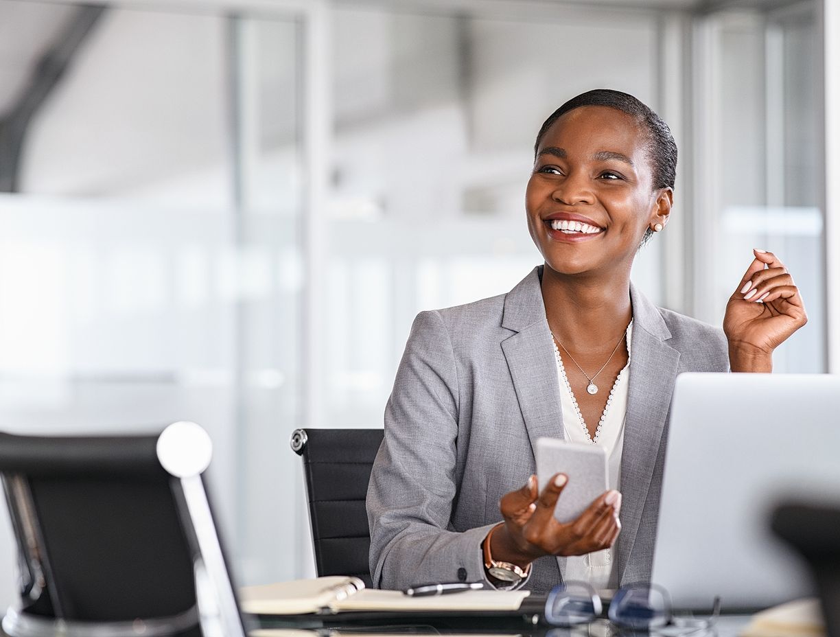 Woman working on phone and computer. 