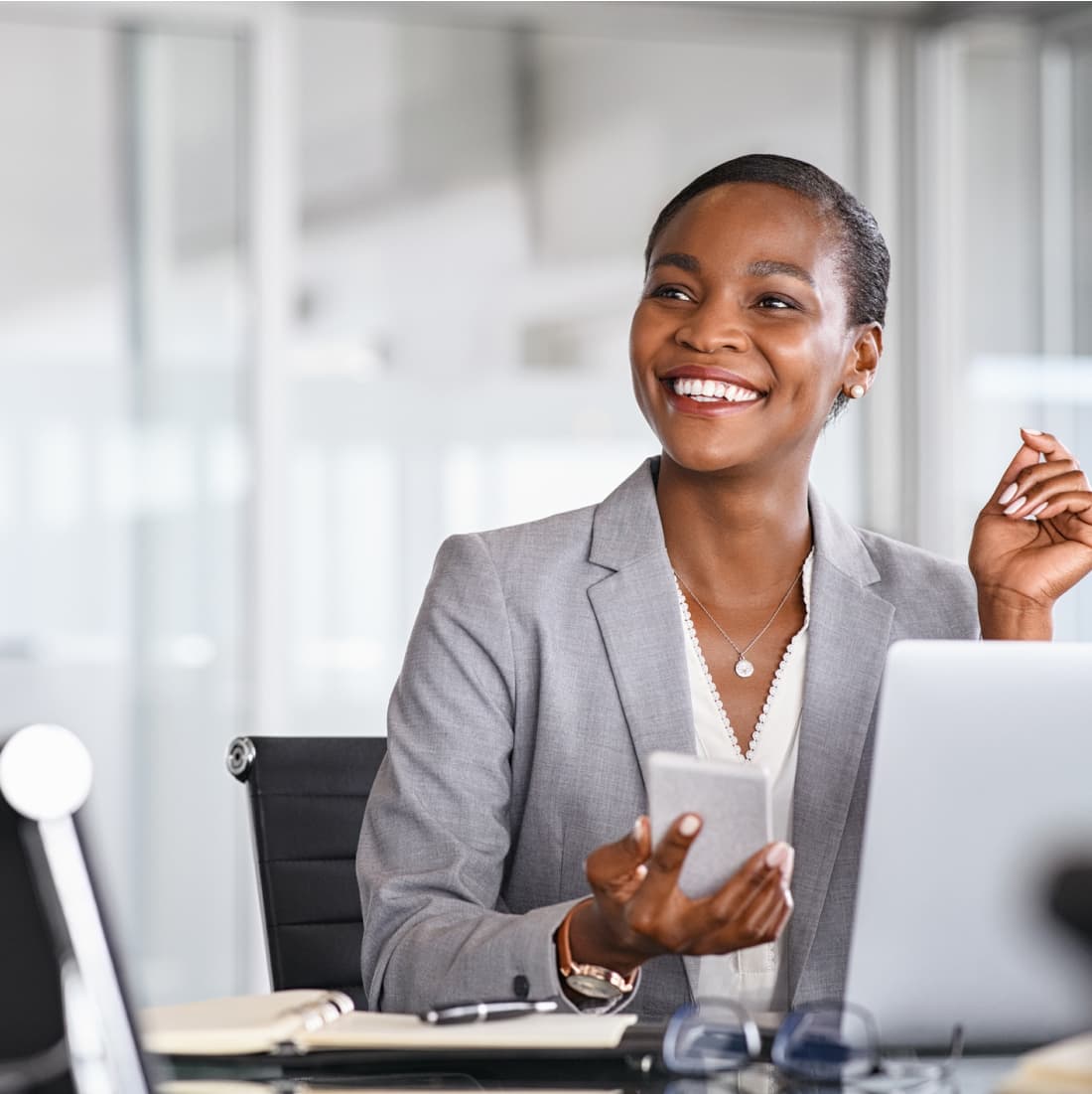 Woman smiling while taking a break from her phone. 