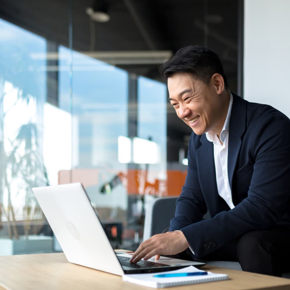 Businessman working on computer and smiling. 