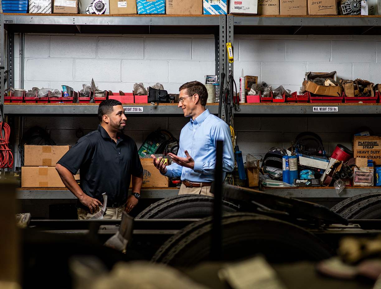 Small business owner meeting with HR Expert in mechanical warehouse. 